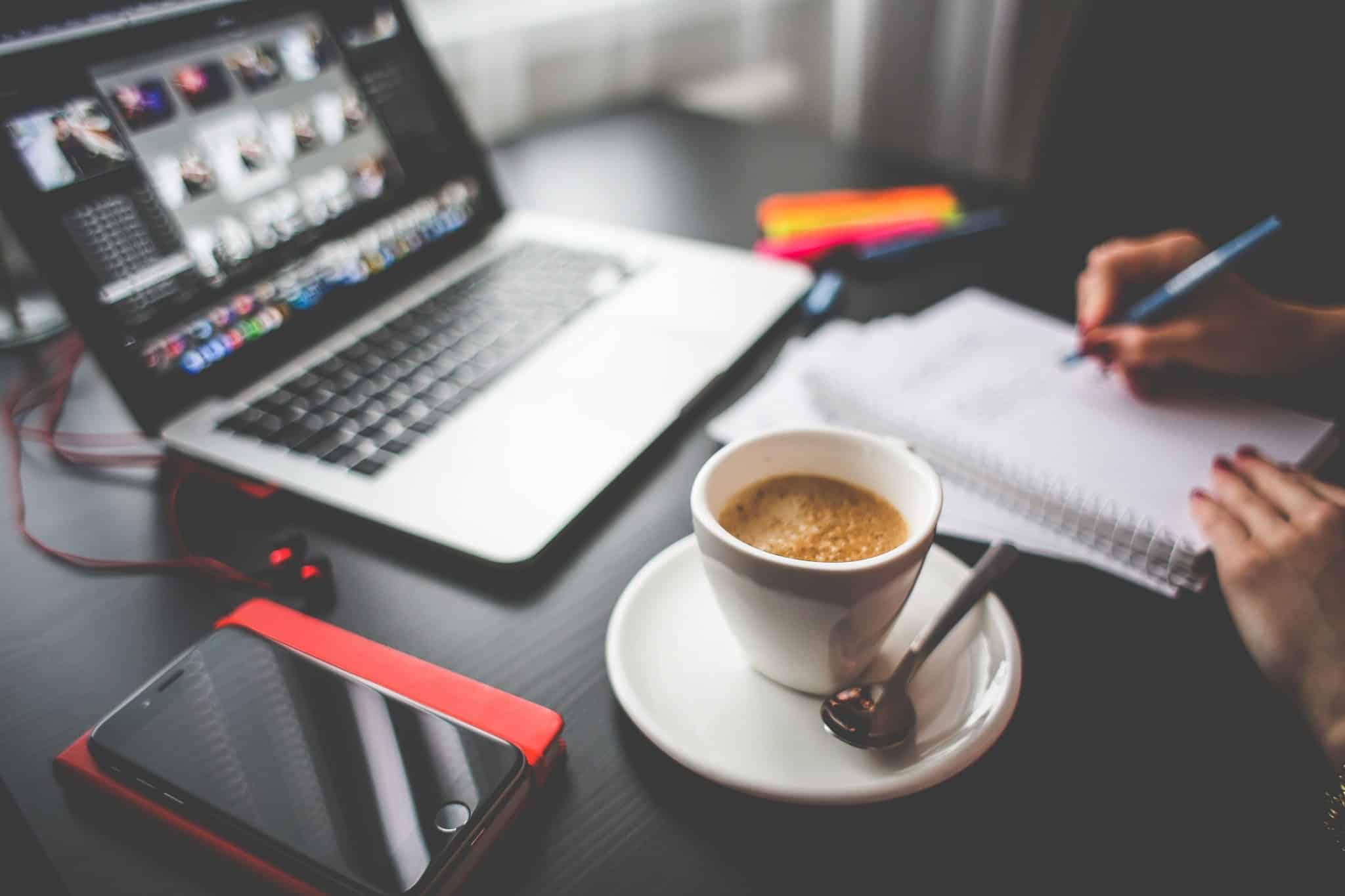 picture of a work desk with laptop and coffee while someone is working on their content marketing strategy