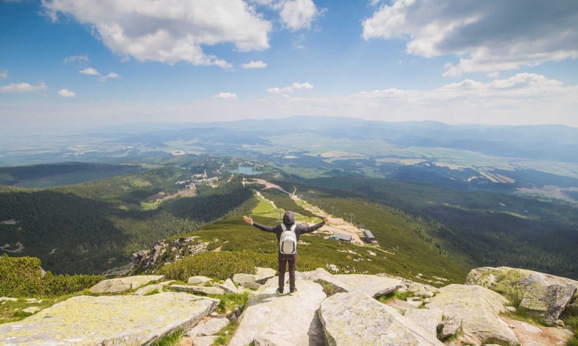 Picture of a man on the top of a hill embracing the world. An illustration in an article about finding the right marketing path.