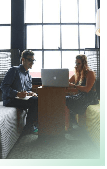 Office space with two people looking at laptop